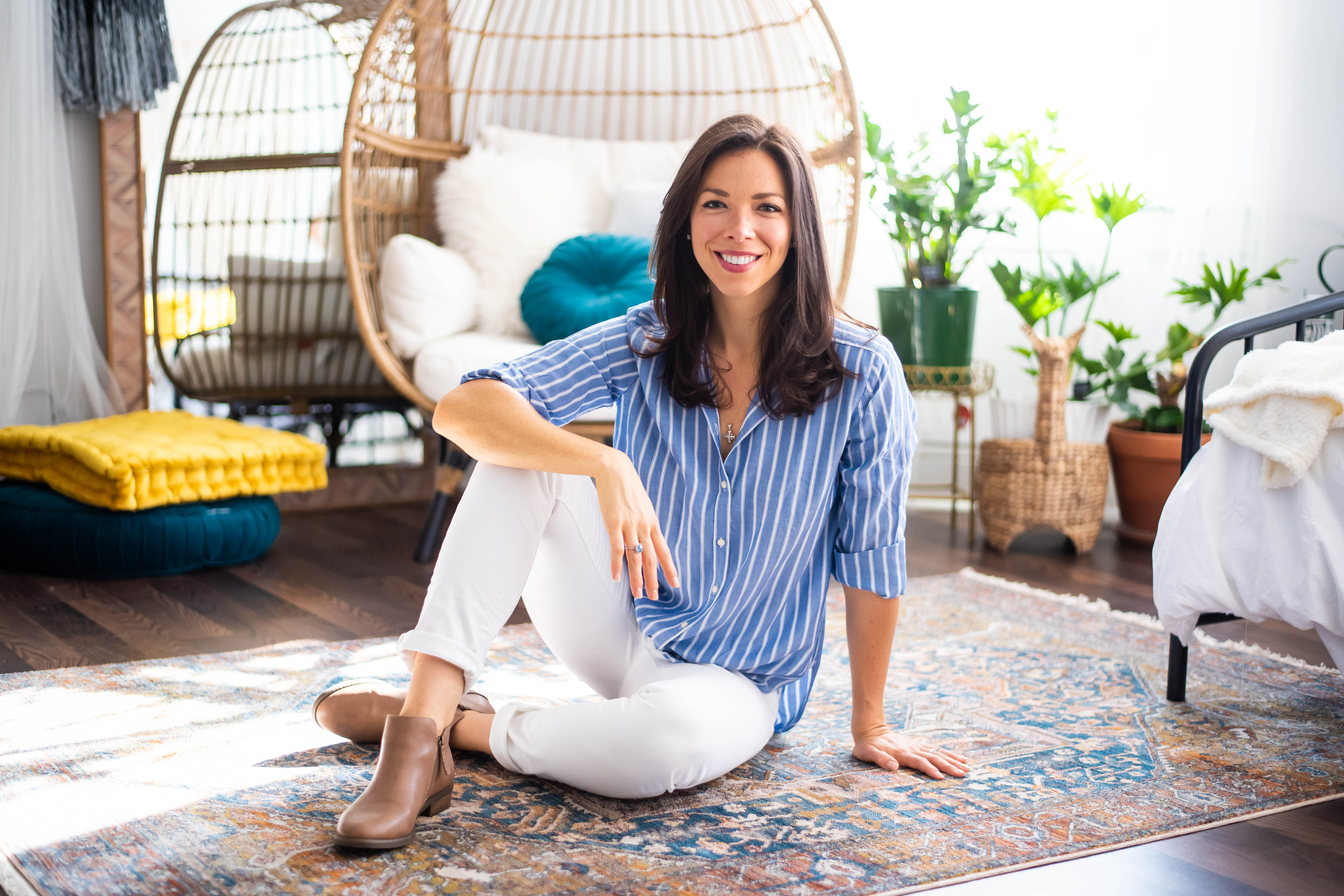 Kate Ziegler smiling and sitting on patterned rug.